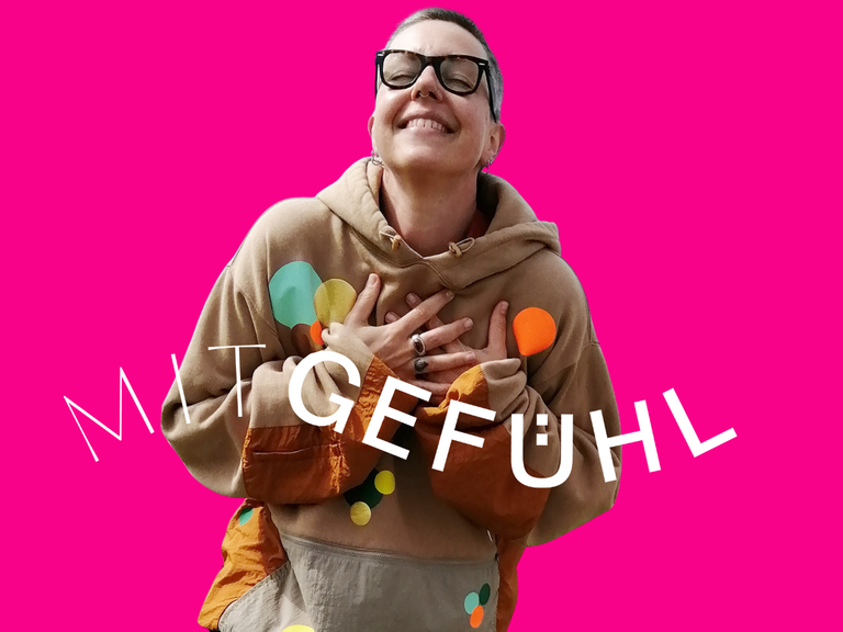 Ein Bild von Julia Kölling lachend mit den Händen auf dem Herzen